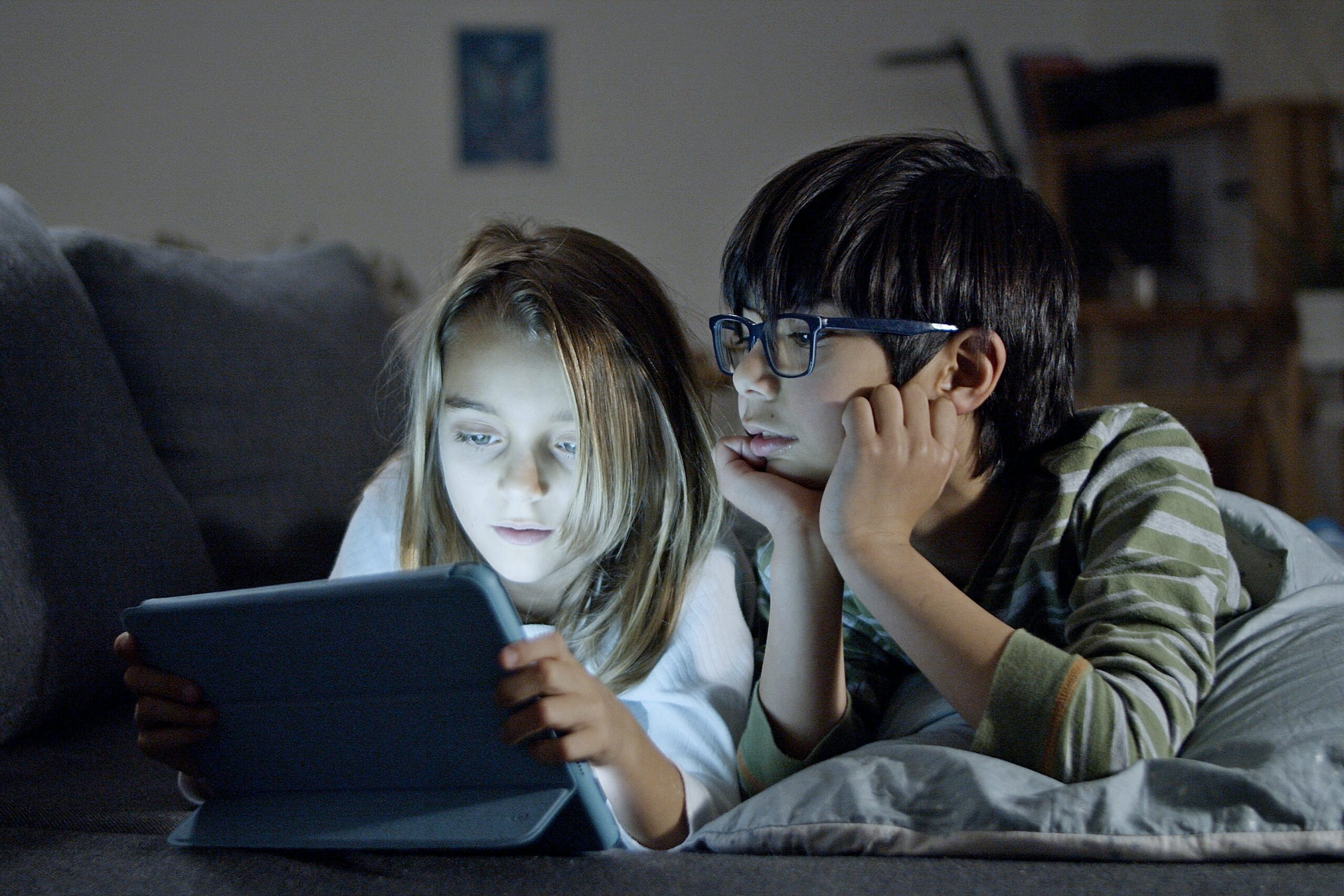 two children looking at a tablet screen